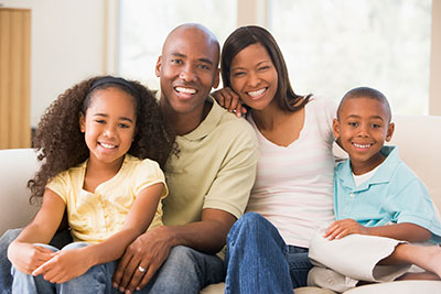 A happy family sitting on a couch.